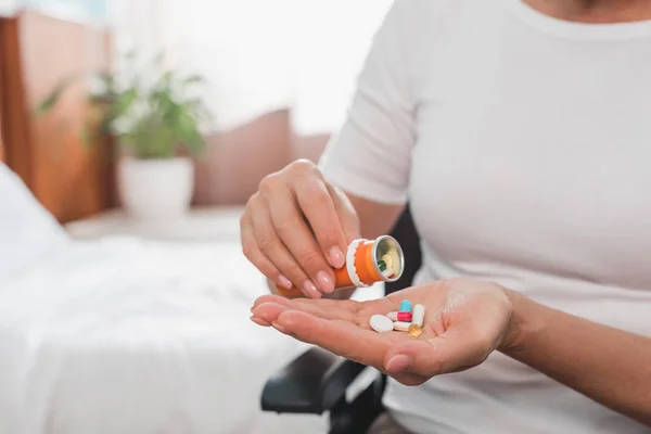 Donna sulla sedia a rotelle che prende la medicina — Foto stock