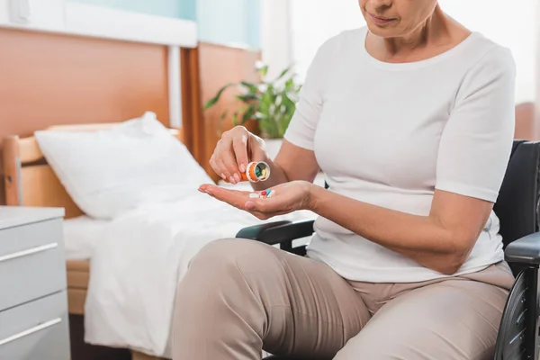 Mujer en silla de ruedas tomando medicamentos - foto de stock