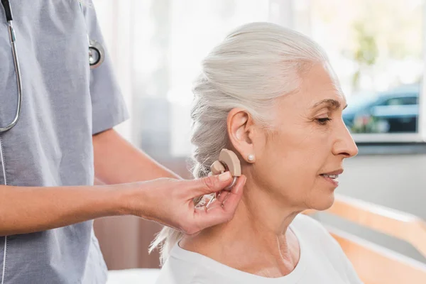 Медсестра и пациент со слуховым аппаратом — стоковое фото