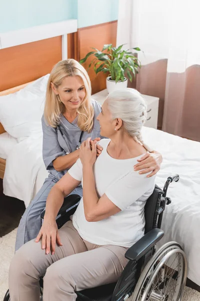 Infirmière et femme âgée en fauteuil roulant — Photo de stock