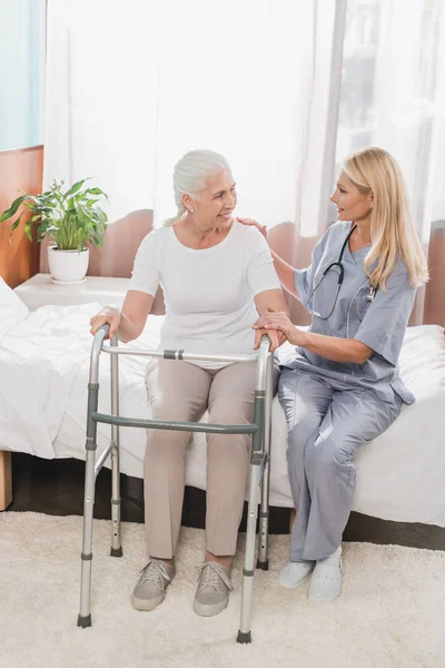Медсестра и старший пациент с ходунком — стоковое фото