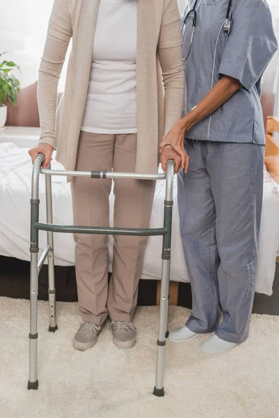 Enfermera y paciente sénior con andador - foto de stock