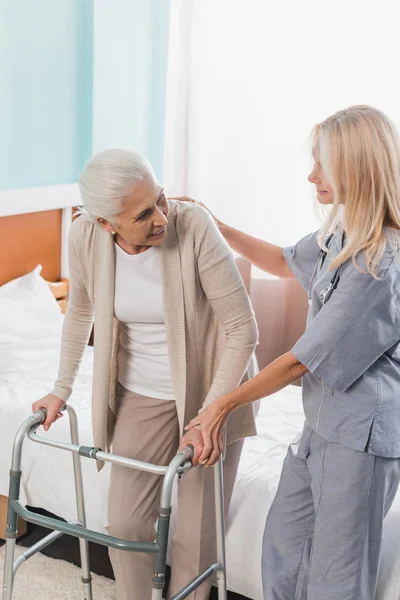Медсестра и старший пациент с ходунком — стоковое фото