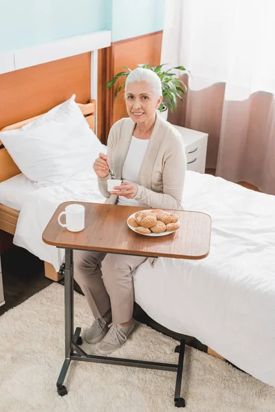 Senior woman eating in hospital — Stock Photo