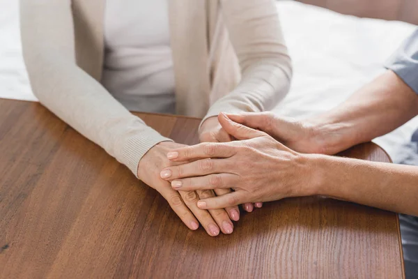 Enfermera y paciente tomados de la mano - foto de stock