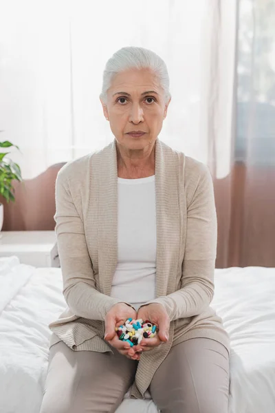 Senior woman holding pills — Stock Photo