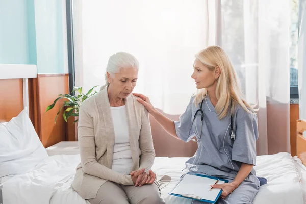 Senior woman and nurse with clipboard — Stock Photo