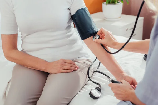 Enfermera midiendo la presión arterial al paciente - foto de stock