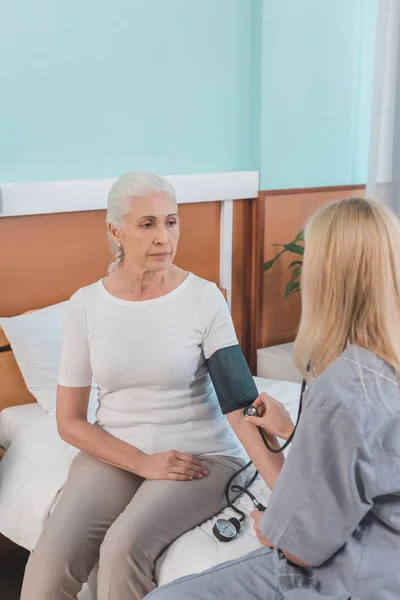 Krankenschwester misst Blutdruck des Patienten — Stockfoto