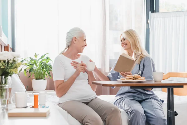 Nurse and patient reading book — Stock Photo