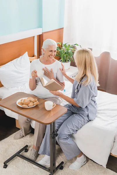 Infirmière et patient livre de lecture — Photo de stock