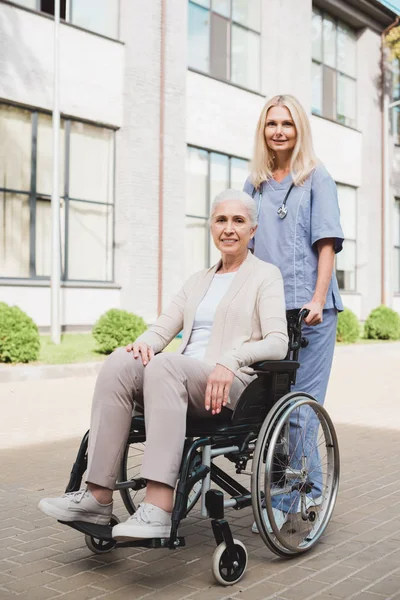 Infirmière et femme âgée en fauteuil roulant — Photo de stock