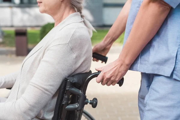Infirmière et femme âgée en fauteuil roulant — Photo de stock