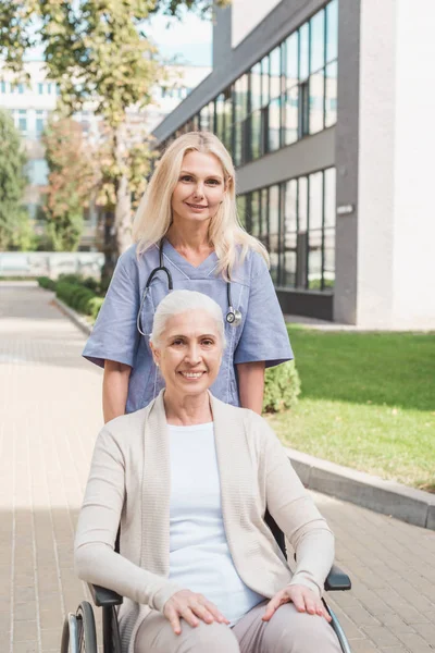 Nurse and senior woman in wheelchair — Stock Photo