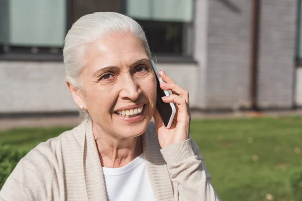 Seniorin spricht auf Smartphone — Stockfoto