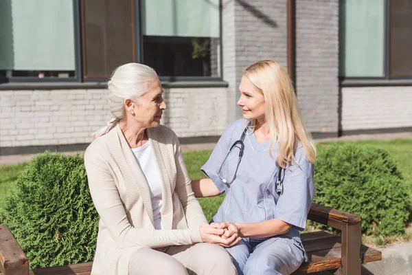 Infirmière et patient tenant la main — Photo de stock