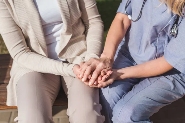 Медсестра і пацієнт тримають руки — стокове фото