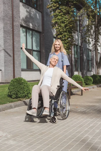 Enfermera y mujer mayor en silla de ruedas - foto de stock