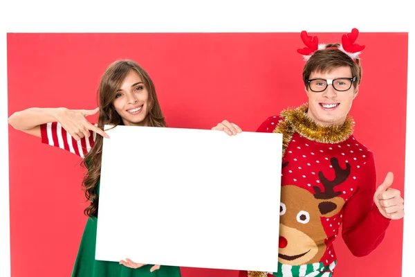 Couple in christmas costumes with banner — Stock Photo