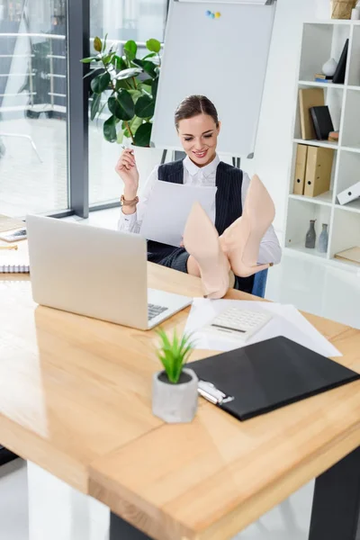 Business woman sitting with feet on desk — Stock Photo