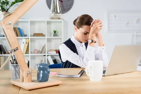 Beunruhigte Geschäftsfrau sitzt am Schreibtisch — Stockfoto