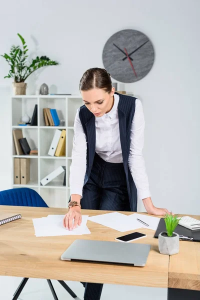 Mulher de negócios olhando para papelada — Fotografia de Stock