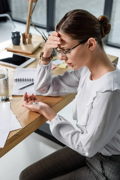 Businesswoman holding pills — Stock Photo