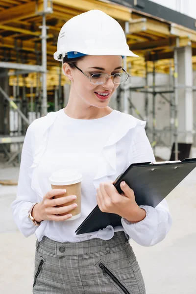 Engineer at construction holding clipboard — Stock Photo