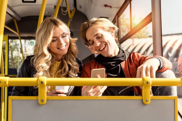Casal com smartphone em transporte público — Fotografia de Stock
