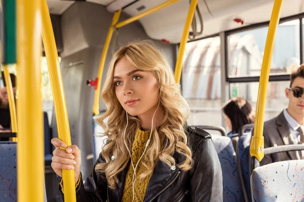 Woman in earphones in city bus — Stock Photo