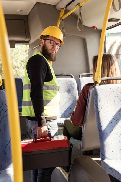 Trabajador con kit de herramientas en autobús - foto de stock