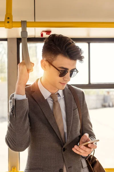 Hombre usando smartphone en autobús urbano - foto de stock