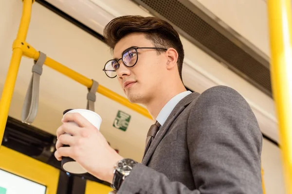 Homem com café para ir em transportes públicos — Fotografia de Stock