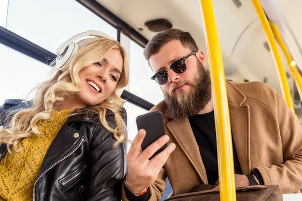 Pareja con smartphone en transporte público - foto de stock