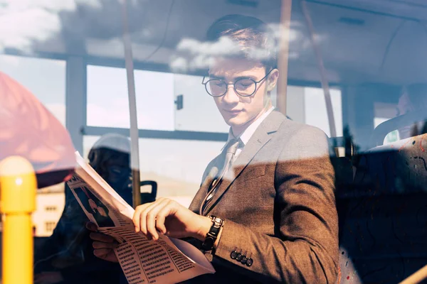 Людина з газетами в громадському транспорті — стокове фото