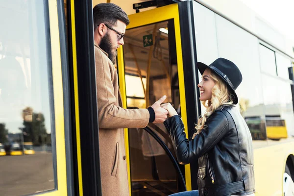 Hombre ayudando novia a entrar en autobús - foto de stock