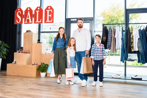 Familia con bolsas de compras en boutique - foto de stock