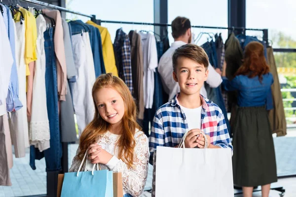 Niños con bolsas de compras en boutique - foto de stock