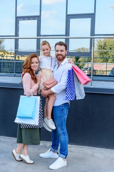 Parents et fille avec sacs à provisions — Photo de stock