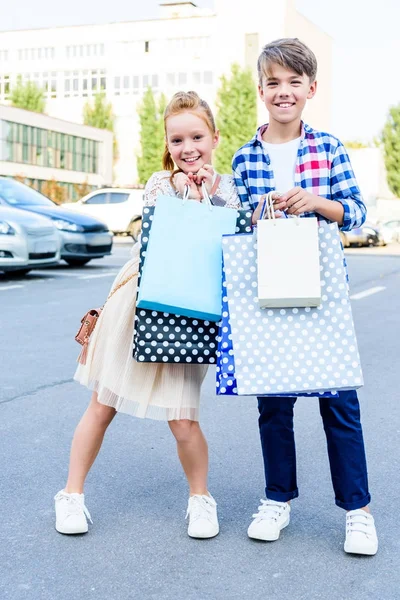 Siblings with shopping bags — Stock Photo