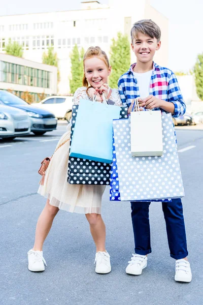 Frères et sœurs avec sacs à provisions — Photo de stock