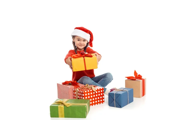 Enfant dans le chapeau de Père Noël avec des cadeaux de Noël — Photo de stock