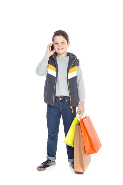 Niño con bolsas de compras y teléfono inteligente - foto de stock