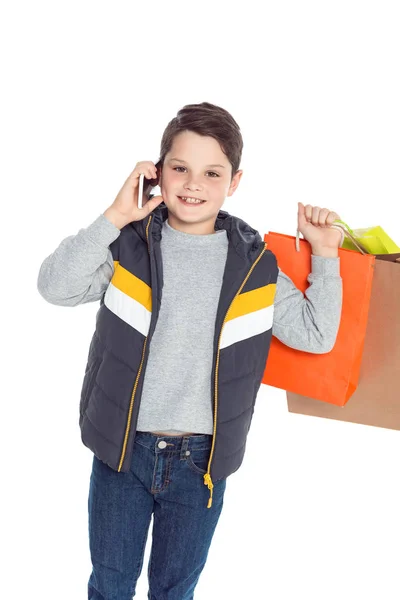 Niño con bolsas de compras y teléfono inteligente - foto de stock