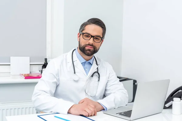 Doctor sitting at workplace — Stock Photo