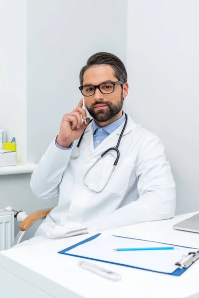 Young doctor talking by phone — Stock Photo