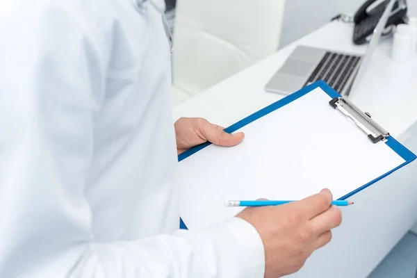 Doctor holding clipboard — Stock Photo