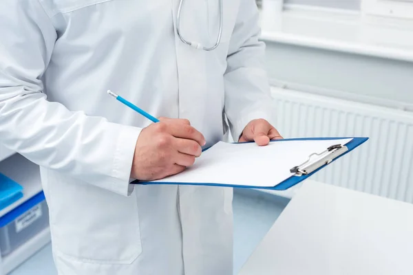 Doctor writing in clipboard — Stock Photo