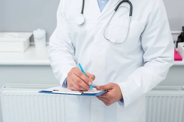 Doctor writing in clipboard — Stock Photo