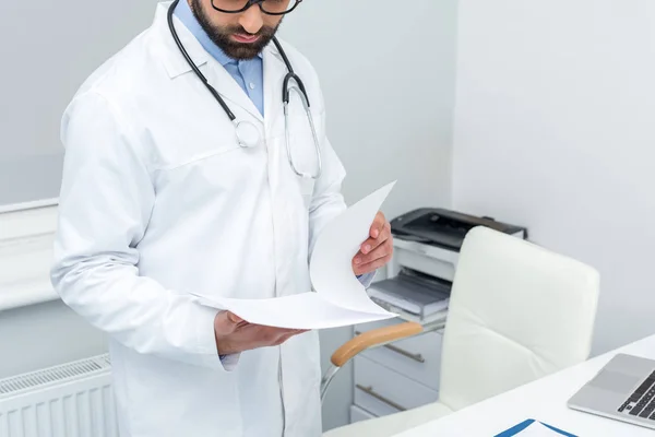 Doctor looking at papers — Stock Photo